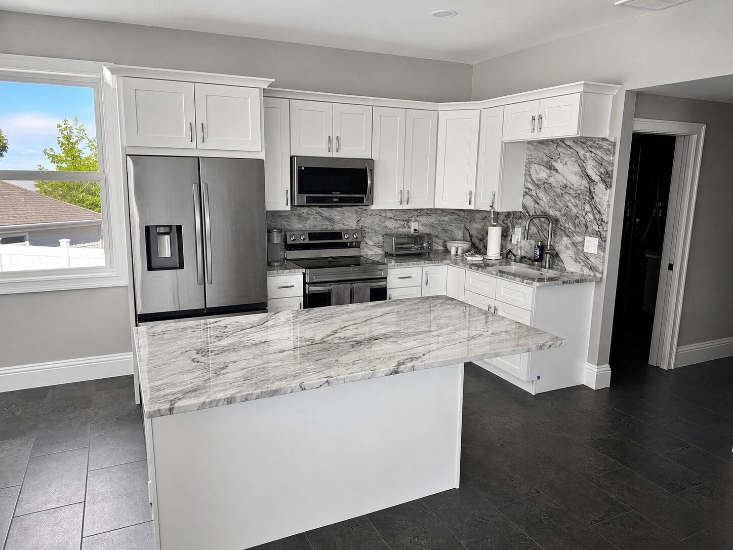 Finished kitchen renovation with coordinated stone surfaces and a bright open layout by Proskillz Remodeling