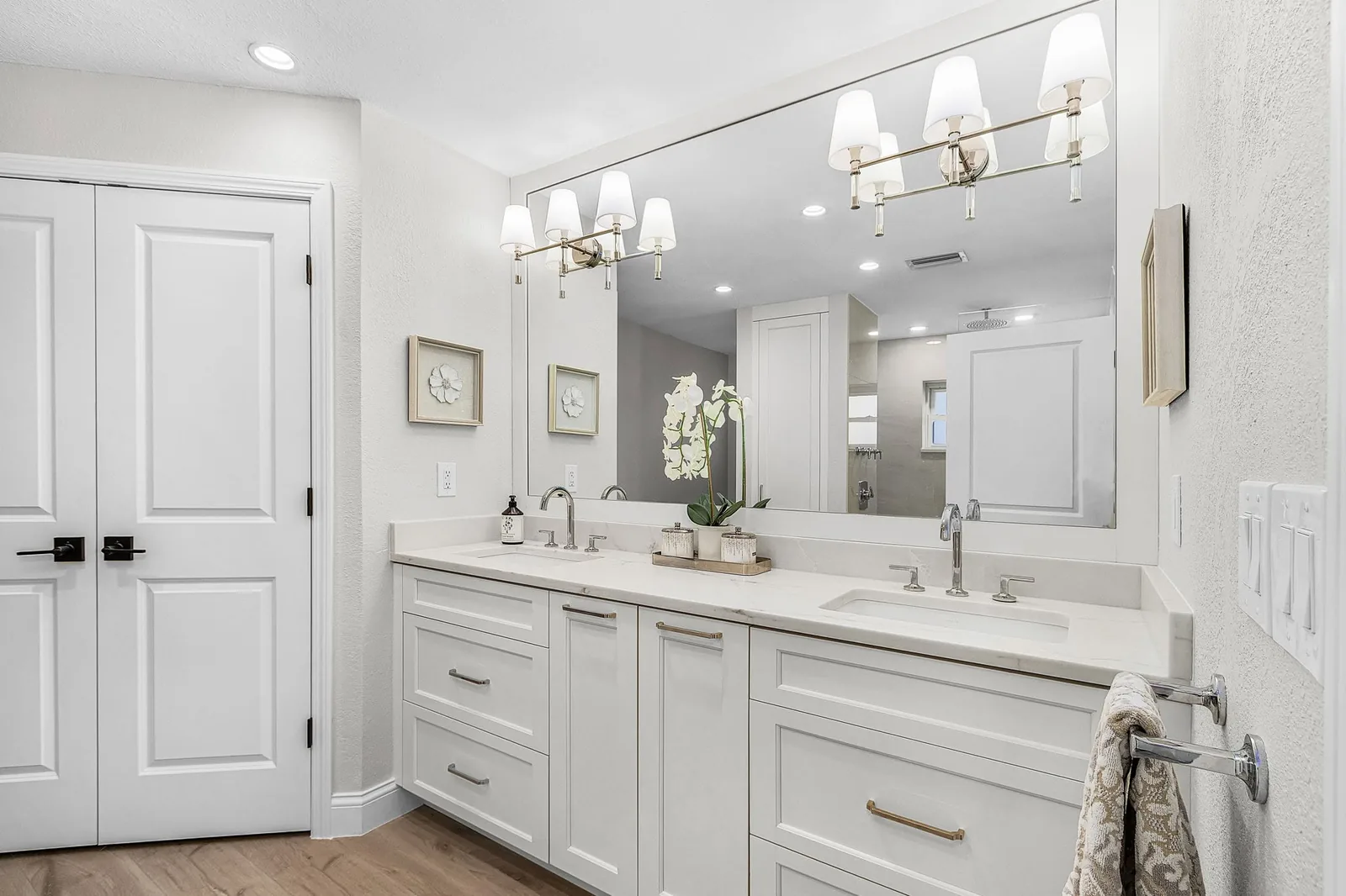 Completed primary bathroom with a double vanity and coordinated finishes by Proskillz Remodeling
