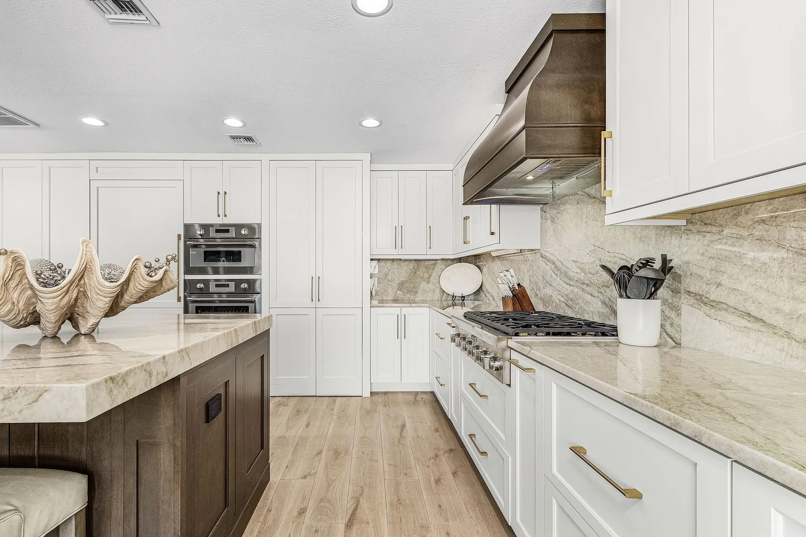 Completed Proskillz kitchen with gold cabinet pulls and coordinated white and wood cabinetry